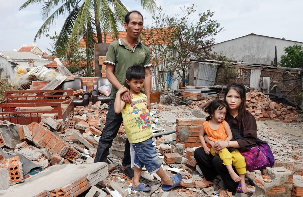 Thái Ngọc Thanh cùng cha anh ngư dân và hai người con trước cảnh căn nhà sụp nát vì cơn bão hoành hành